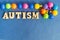 The word autism is made of simple wooden letters, and puzzles are made of multi-colored beads. Autism Day. Space for text