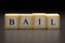 The word BAIL written on wooden cubes isolated on a black background