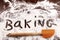 Word baking written in white flour on wooden table