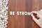 Word be strong made with block wooden letters