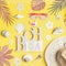 Word beach with straw hat , sunglasses, shells and tropical leaves on yellow background, top view. Summer flat lay