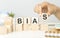 The word BIAS, spelt with wooden letter tiles over