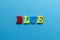 Word `blue` from plastic coloured magnet letters on blue paper b