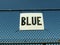 Word blue written on white board against blue sky
