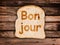 Word bonjour written on a toasted slice of bread