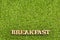 Word breakfast in wooden letters - Green grass.