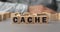 The word CACHE made from wooden cubes. Shallow depth of field on the cubes