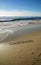 The word California written in sand on the beach.