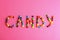 Word CANDY made of different glazed candies on background, flat lay