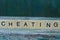 Word cheating from brown wooden letters