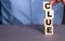 The word CLUE the man composes from wooden cubes vertically