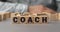 The word COACH made from wooden cubes. Shallow depth of field on the cubes