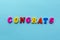 Word `congrats` from magnetic letters on blue paper background