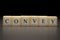 The word CONVEY written on wooden cubes isolated on a black backgrond