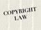 The word COPYRIGHT written and highlighted in front of of blurred text columns on background of light yellow color