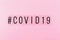 Word coronavirus and hashtag on pink background