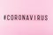 Word coronavirus and hashtag on pink background