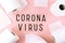 Word coronavirus and toilet paper on pink background