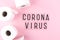 Word coronavirus and toilet paper on pink background