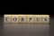 The word CORPUS written on wooden cubes isolated on a black background