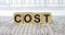 Word Cost made with wood building blocks