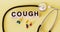 the word Cough written on a wooden block. cough text on a yellow background,