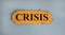 Word `crisis` on the piece of cardboard on a beautiful white background, copy space