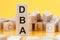 Word dba from wooden blocks with letters, concept