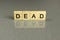 Word dead, made of square wooden letters on a gray background