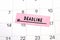 The word Deadline written on a pink sticky note posted on a calendar or planner page. Deadline concept read a reminder on calendar