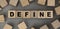 The word DEFINE made from wooden cubes. Conceptual photo