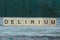 Word delirium made of wooden letters on a gray table