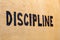 The word discipline burnt on white flat wooden surface - perspective view with selective focus