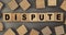 The word DISPUTE on small wooden blocks at the desk. Top view