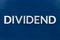 The word dividend laid with brushed metal letters on dark blue background