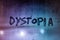 the word dystopia handwritten on wet window glass surface