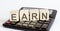 Word EARN on a wooden block on calculator