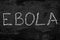 The word ebola written with chalk on black stone.