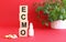 The word ECMO is made of wooden cubes on a red background. Medical concept