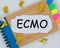 The word ecmo is written on a torn piece of paper on a notepad. the concept of business, marketing