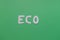 Word `eco` on a green background. Flat lay. Top view. Ecology concept.