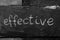 The word EFFECTIVE written with chalk on black stone.