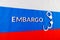 the word embargo laid with silver metal letters on russian tricolor flag with silver handcuffs