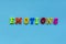 Word `emotions` of colored plastic magnetic letters on blue paper background.