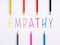 The word empathy and colorful crayons on white background