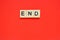 Word end. Top view of wooden blocks with letters on red surface