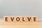 The word EVOLVE on wooden cube block on wood table