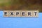 Word expert made of brown wooden letters
