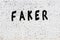 Word faker painted on white brick wall