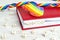 Word Family written in wooden blocks in red notebook with rainbow LGBT ribbon on wooden table